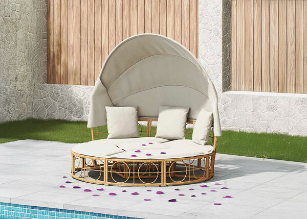 Lit de jardin avec baldaquin et coussins et sol recouverts de p&eacute;tales violets.